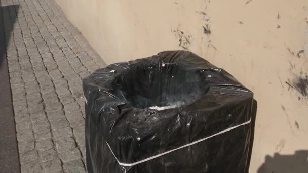 Un bote de basura está ardiendo en la calle. Ondas de humo de la basura — Vídeos de Stock