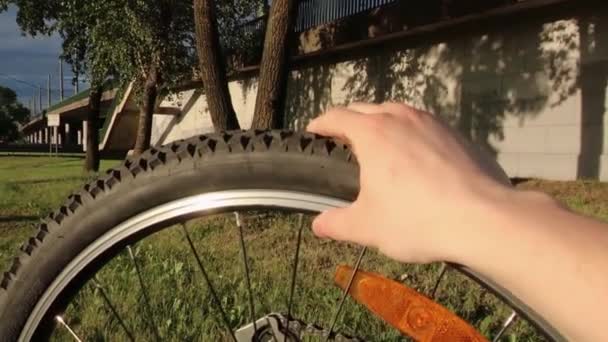 En hand griper tag i ett deflaterat cykelhjul. Pierced cykel — Stockvideo