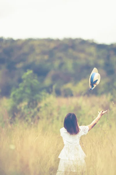 Jovem mulher satnding e jogando chapéu — Fotografia de Stock