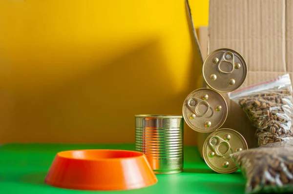 Bowl of a pet with food. Box, cans of canned food. Concept delivery of pet food Stock Picture