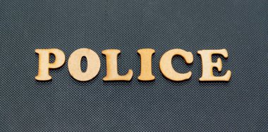 Siyah arka planda tahta harflerle yazılmış bir polis..