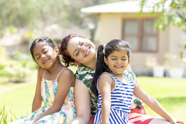 Love between a young mother and her two pretty daughters outdoors