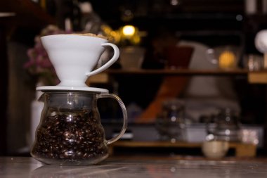 Ahşap bir masa üzerinde kahve çekirdekleri ile Cam Kavanoz