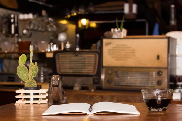 Tazza di caffè nero e diario scrivania in legno — Foto Stock