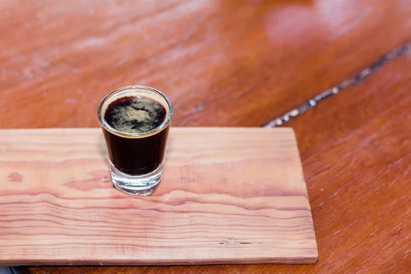 Черный кофе в прозрачном стекле помещается на деревянный стол . — стоковое фото