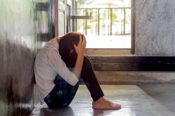Κατάθλιψη νεαρή γυναίκα που κάθεται σε άδειο δωμάτιο, θλιβερή γυναικεία κατάθλιψη. — Φωτογραφία Αρχείου