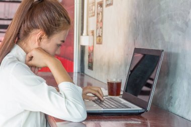 Genç iş adamları bir kafede bir bilgisayarda çalışma hakkında düşünüyorsun.