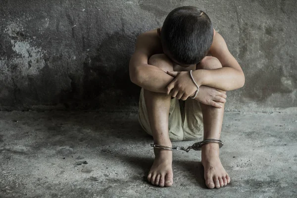 Ребенок стал жертвой торговли людьми, ноги связаны кандалами в эмоциональном стрессе — стоковое фото