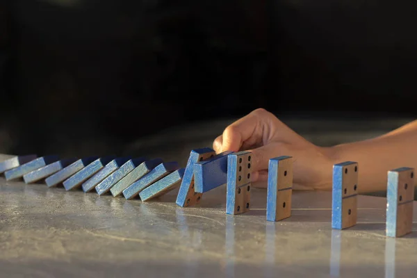 Businesswomen hand Stopping Falling wooden Dominoes effect from continuous toppled or risk, — Stock Photo, Image