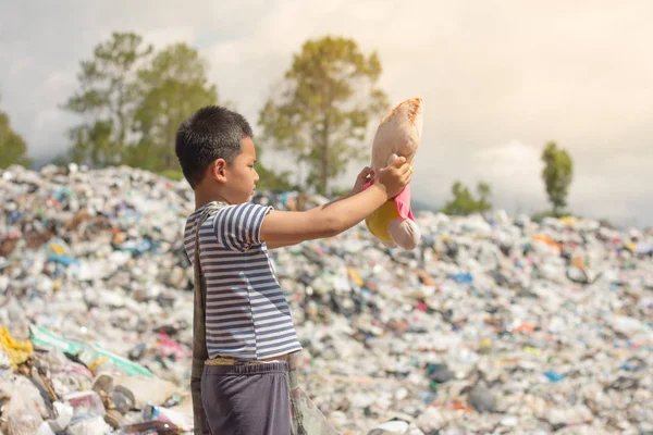 Niños de pie mirando a las muñecas recogidas de la basura, las vidas y estilos de vida de los pobres, El concepto de trabajo infantil y el tráfico — Foto de Stock