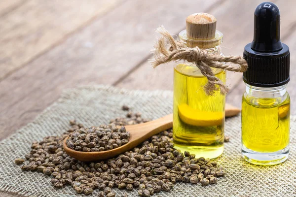 Semillas de cáñamo en cuchara de madera y aceite esencial de cáñamo. Copiar espacio . —  Fotos de Stock