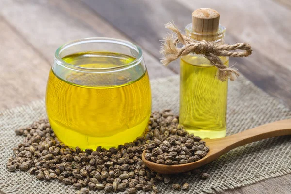 Hennepolie in een glazen pot en hennepzaad op bruine houten tafel. Cb — Stockfoto