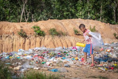 Fakir bir çocuk çöplükten çöp topluyor. 