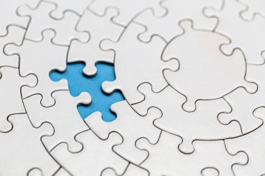 Mavi arka planda tamamlanmamış beyaz puzzle parçaları, La