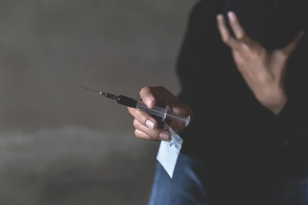 A man who is addicted to carrying heroin and syringe in his hand — Stockfoto