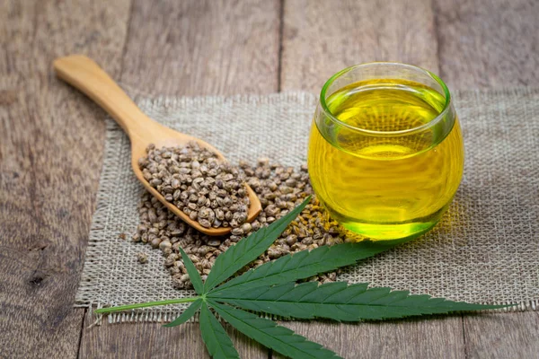 Cbd Hanföl, Marihuanapflanze und Cannabisöl auf Holztisch, — Stockfoto