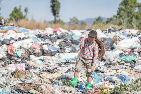 Un pobre chico recogiendo basura de un vertedero en el — Foto de Stock