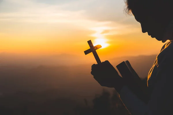 Las mujeres oran a Dios con la Biblia y la cruz con el sol de la mañana — Foto de Stock