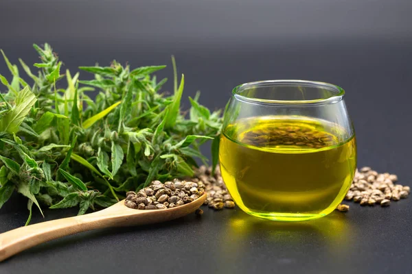 Hennepzaad en hennepolie in een glazen pot op een zwarte achtergrond. mij — Stockfoto