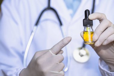 doktor el Esrar p karşı Esrar yağı şişesi tutan