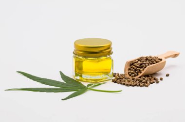 Ahşap bir kaşıkta kenevir yağı ve kenevir tohumu yığını Beyaz bir torba üzerinde