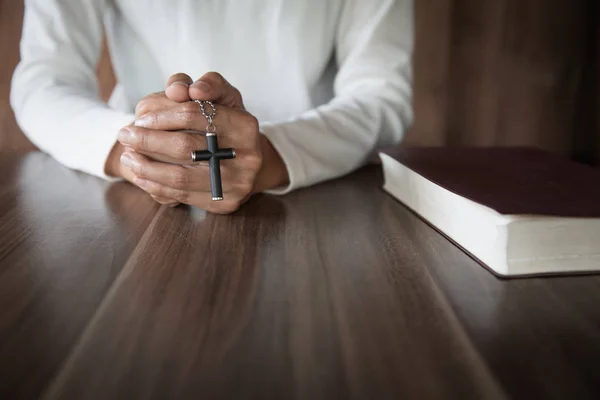 Donna che tiene una croce tra le mani e prega. Pregate per i blessi — Foto Stock