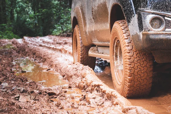 Dirty offroad car, SUV covered with mud on countryside road, Of