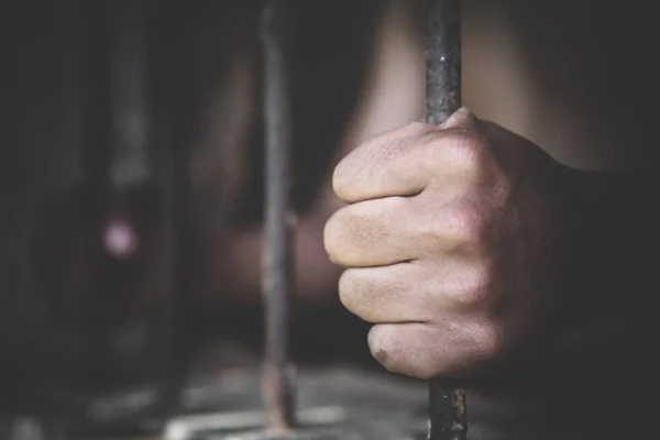 Muž ve vězeňských rukou za držet ocelové klece vězení mříže, Muž p — Stock fotografie