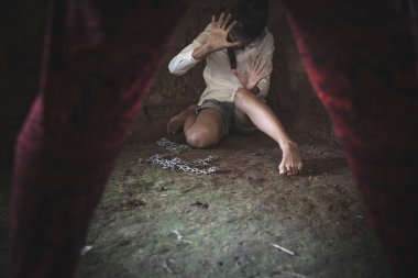 Ayakta duran ve elinde zincir tutan bir adam...