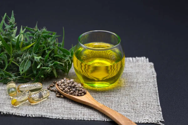 Hennepzaad en hennepolie in een glazen pot op een zwarte achtergrond. mij — Stockfoto