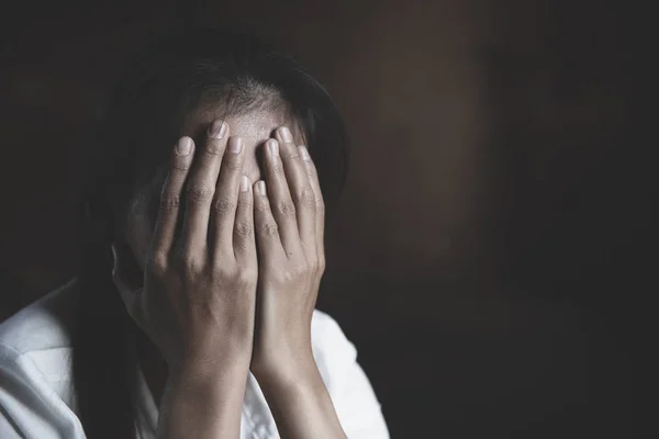 Jong meisje zitten in donkere kamer gevoel pijn met het leven probleem. — Stockfoto