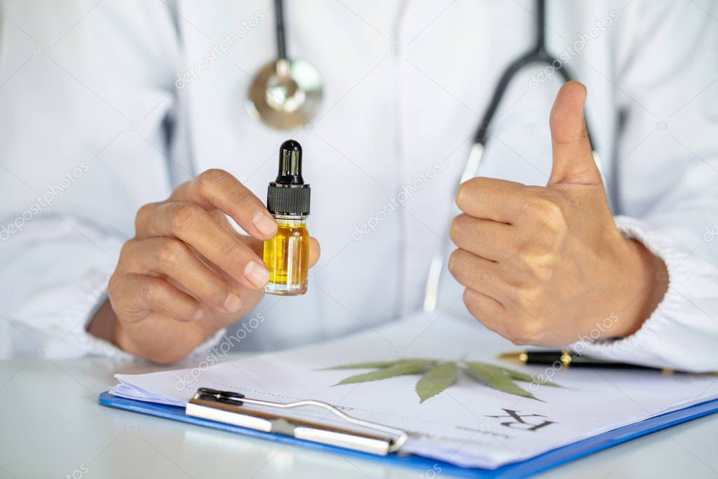  Doctors  holding bottle of Cannabis oil in pipette,hemp product