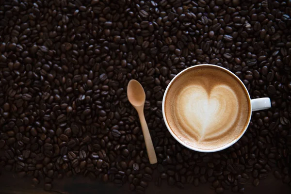 Kávové latté s kávovými zrny na tmavém pozadí, horní pohled — Stock fotografie