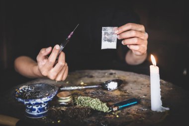 Elinde şırınga ve aşırı dozda uyuşturucu olan genç bir kadın.