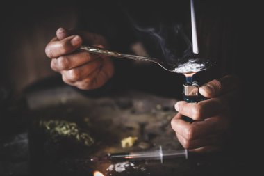 Karanlık odada uyuşturucu bağımlıları. Bağımlı / bağımlı uyuşturucu hazırlıyor