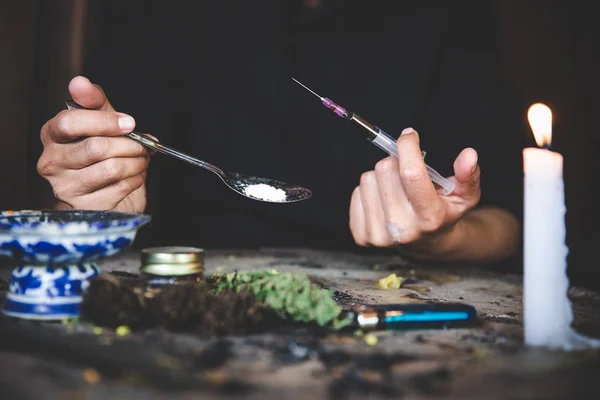 Mão humana de um viciado em drogas e uma seringa com seringa narcótica — Fotografia de Stock