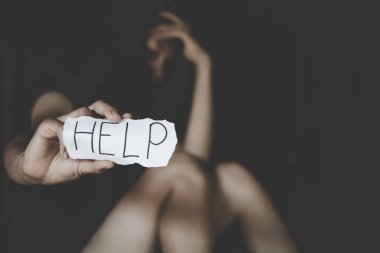 Kadınlar depresif bir ifadeyle yalnız oturuyor ve bir papaz gösteriyorlar.