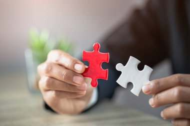 Beyaz ve kırmızı bulmacaları birleştiren iş kadınları, karar vermede işbirliği, sorunları çözmede takım desteği ve şirket takım çalışması kavramı.