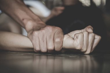 Tecavüz ve cinsel taciz konsepti için el ele tutuşan bir erkek, aile içi şiddet, cinsel saldırı konsepti, Uluslararası Kadınlar Günü