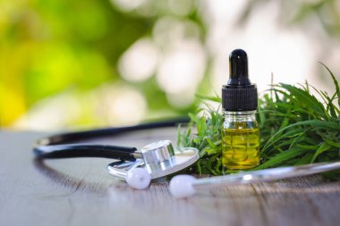 Cbd petrol kenevir özü, kenevir yağı şişeleri ve ahşap bir masa üzerinde kenevir çiçekleri, Tıbbi esrar kavramı