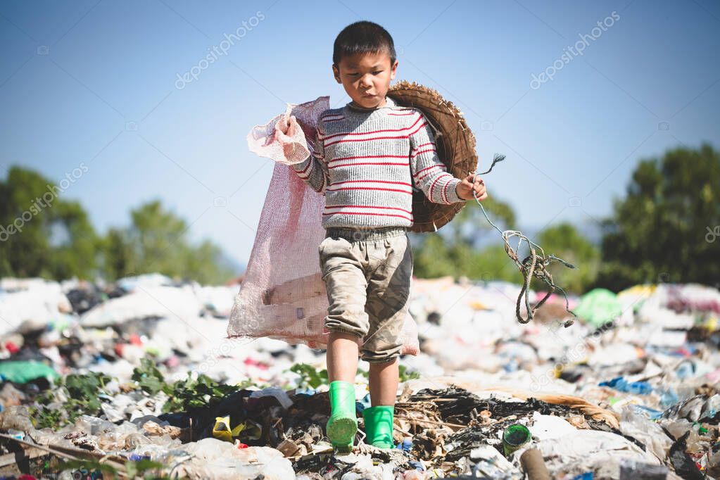 A poor boy collecting garbage waste from a landfill site in the outskirts, the lives and lifestyles of the poor, Child labor, Poverty and Environment Concepts