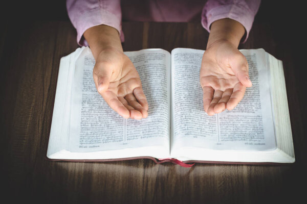 Religious Christian Child  praying over Bible indoors, Religious concepts. Religious beliefs Christian life crisis prayer to god.