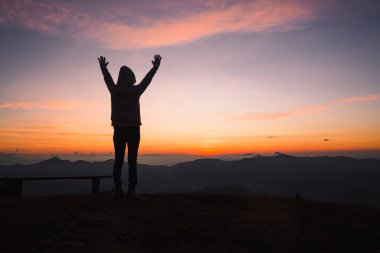 Gün batımında dua eden Hristiyan bir kadının silueti. Hıristiyan Dini kavramı geçmişi. Dua eden eller. Tanrı 'ya din kavramı ile tapmak.