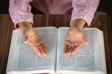 Hıristiyan dini için dua ederken çocuk eli, sıradan bir kadın kutsal İncil ve din kavramı ile dua ediyor..