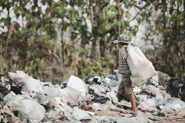 A poor boy collecting garbage waste from a landfill site. Concept of livelihood of poor children.Child labor.