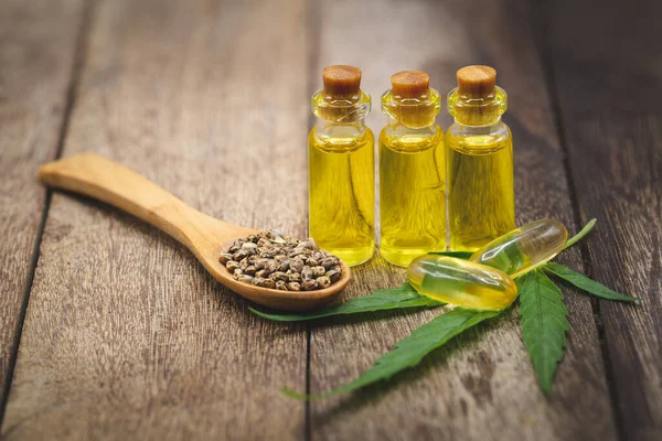 Hanfsamen Und Hanföl Auf Braunem Holztisch Hanfsamen Holzlöffel Und Ätherisches — Stockfoto