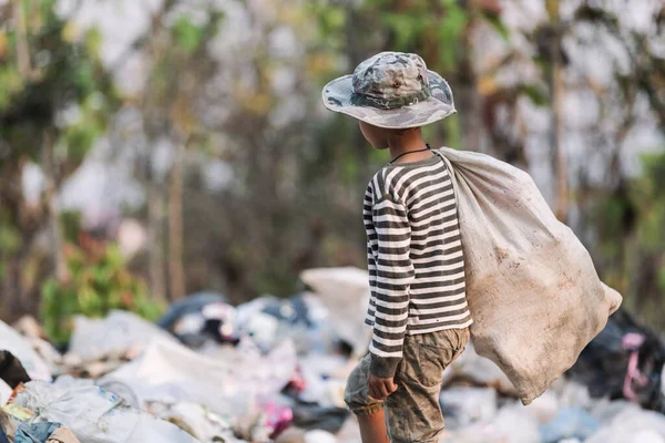 埋め立て地からゴミを集める貧しい少年 貧しい子供の生活の概念 児童労働 人身売買 貧困の概念 — ストック写真