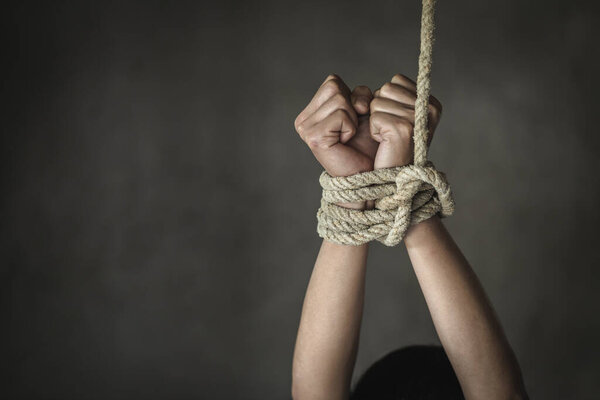 Hands tied up with rope of a missing kidnapped,  Victims of the human trafficking.  Abused and tortured concept. Stop violence against Women. International women's Day. Stop abusing violence.