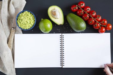 Geleneksel neşeli Meksika sosu guacamole seramik kase ve malzemelerin koyu arka plan üzerine. Not defteri. Üstten Görünüm. Düz yatıyordu. Kopya alanı.