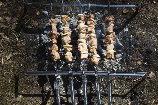 Carne de porco suculenta e deliciosa kebab em espetos grelhando na grelha aberta. Conceito de festa churrasco ao ar livre. No início da primavera. Fundo de carne. Vista de perto . — Fotografia de Stock
